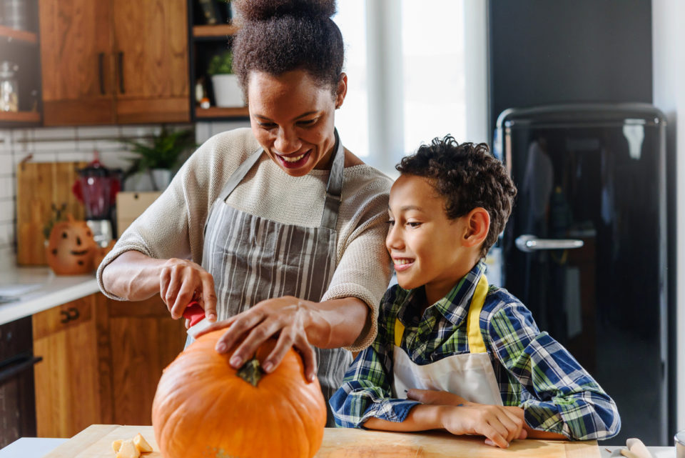 Mother and son carving pumpkin for Halloween