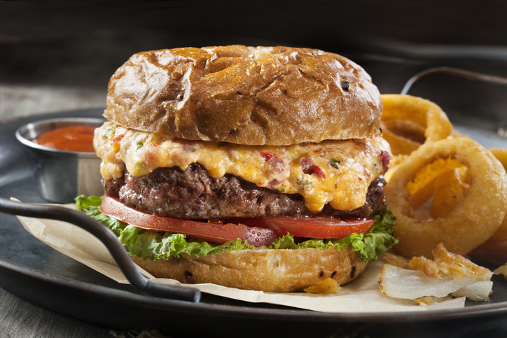 Pimento Cheese Burger with Lettuce, Tomato and Thick Cut Onion Rings on a Toasted Onion Bun