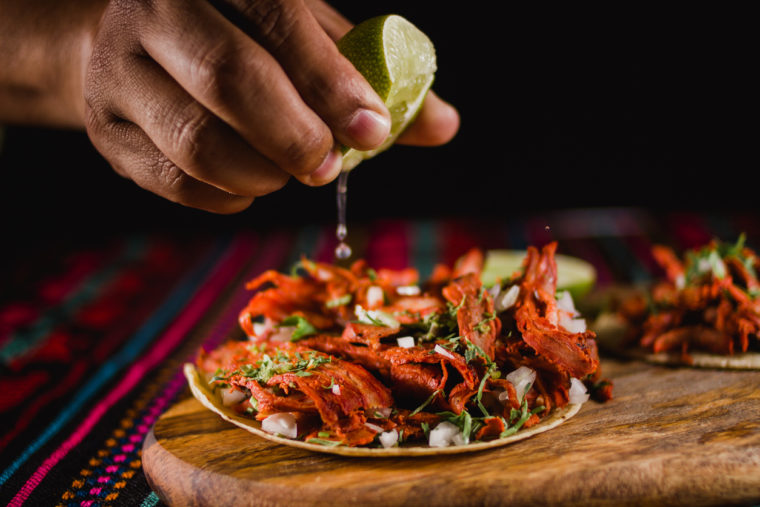 Mexican taco al pastor is traditionally eaten with lime juice