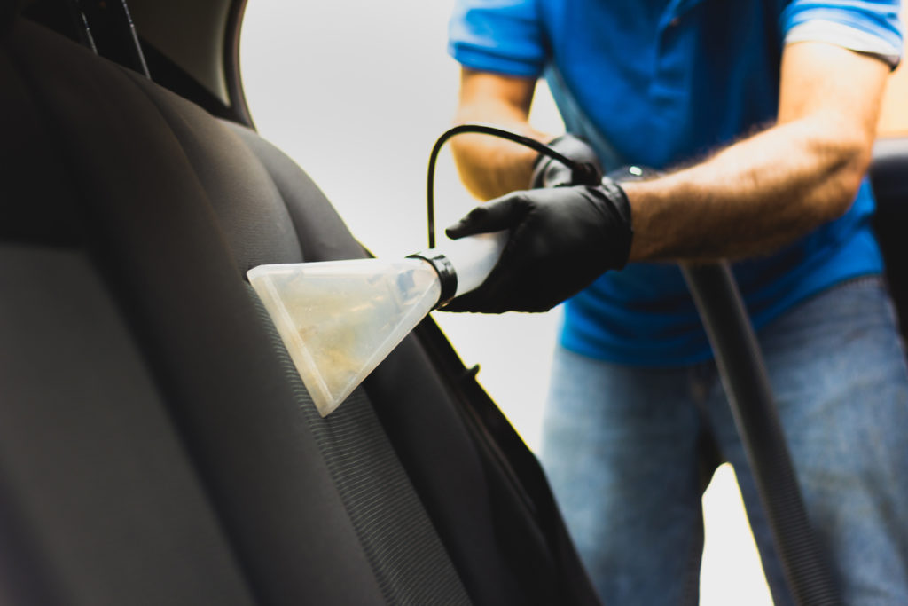 Man cleaning his vehicle upholstery