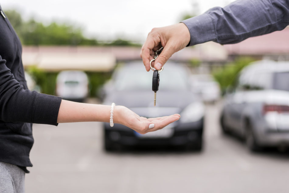 Customer and dealership salesperson exchanging keys
